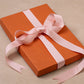 gift box in orange with pink bow