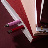 book stack with pens sticking out