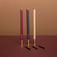 Three makeup pencils with gold accents on a brown background