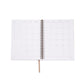 Open spiral-bound planner with grid layout on white background