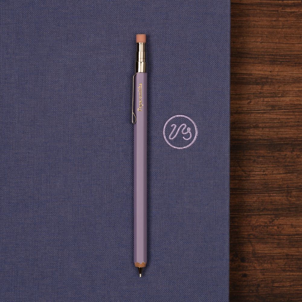 Purple pencil on a blue surface with a logo, on a wooden surface