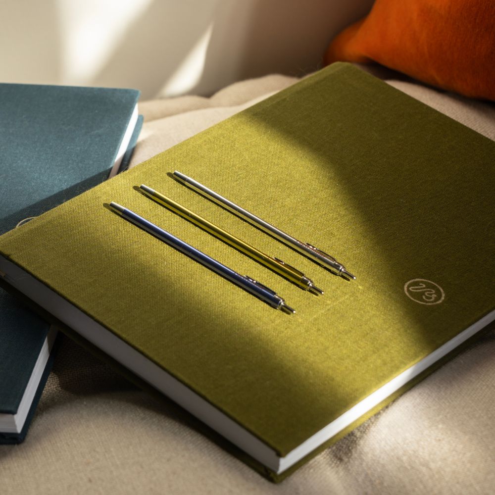3 pocket-sized pens on a green notebooks by Papersmiths