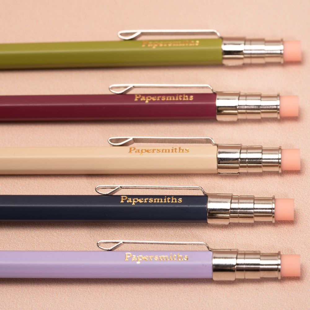 Five colorful pens with 'Papersmiths' branding on a beige background